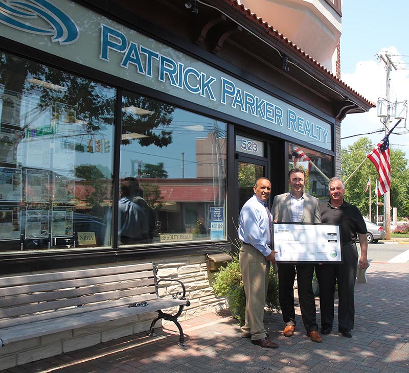 Freeholder Thomas A. Arnone, joined by Bradley Beach Councilman Norman Goldfarb (right), presents a Monmouth County Façade Improvement Program check for $1,850 to Patrick Parker (center), owner of Patrick Parker Realty, on Aug. 17 in Bradley Beach, NJ.
